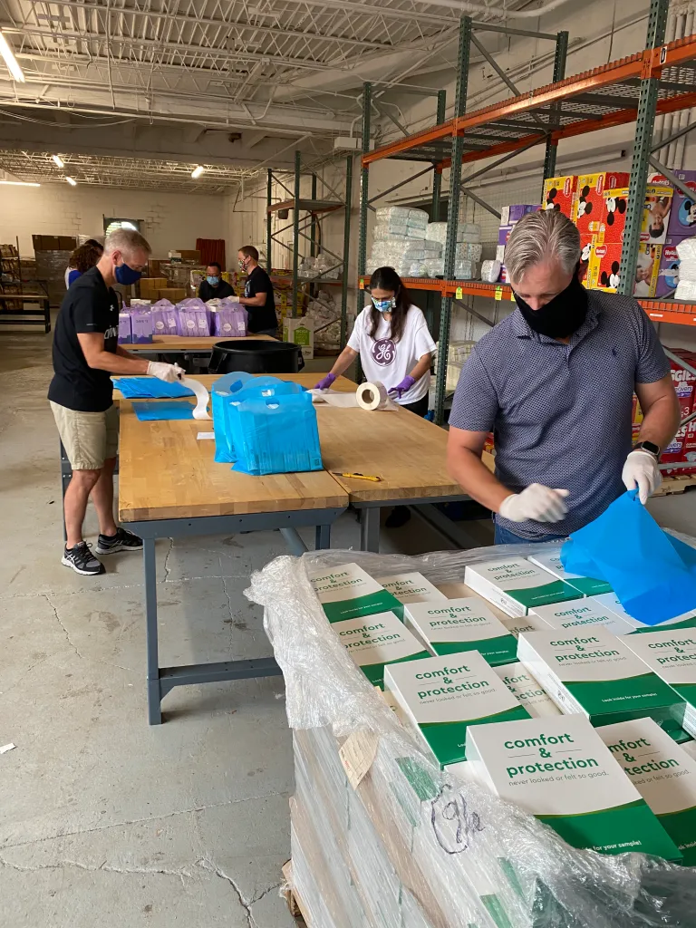 Volunteers wrapping free period supplies that are distributed by Fly & Dry Basic Needs Bank.